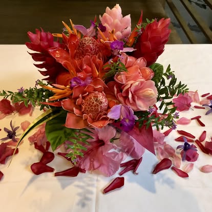 Bouquet centerpiece surrounded by scattered flower petals