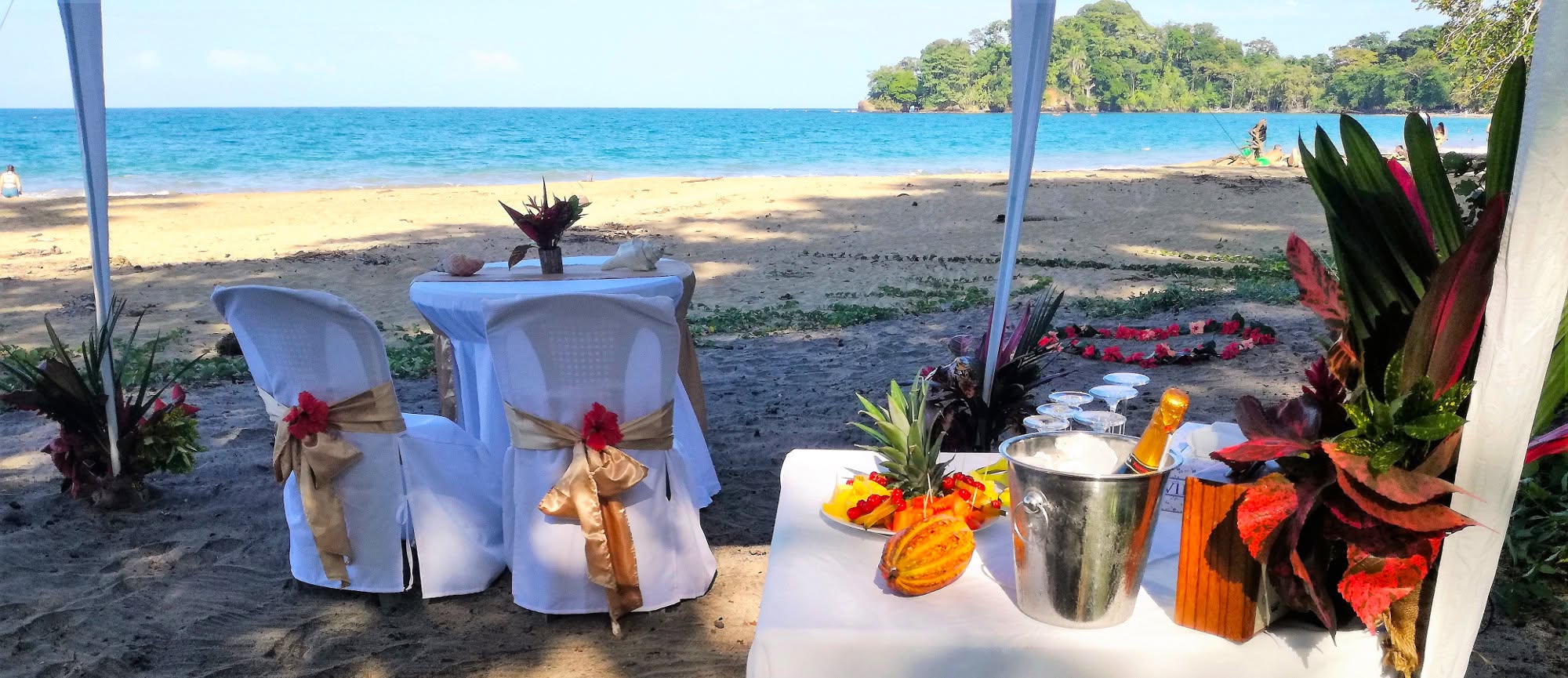 Beachfront wedding table with champagne and fresh fruit